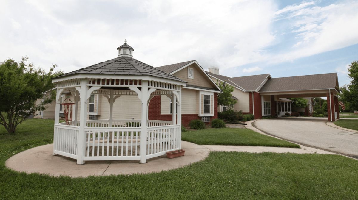 A suburban house with a white gazebo in the front yard.