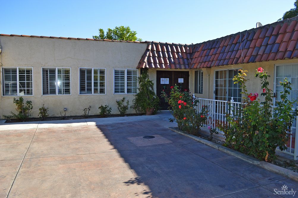 A single-story residential house with a driveway and garden.