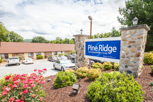 Welcome to Pine Ridge, a cozy motel surrounded by beautiful landscaping.