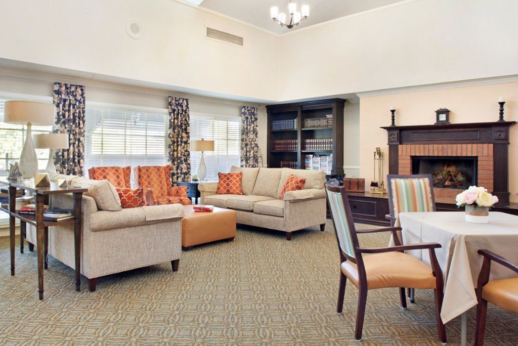 A cozy living room with sofas, a fireplace, and large windows.