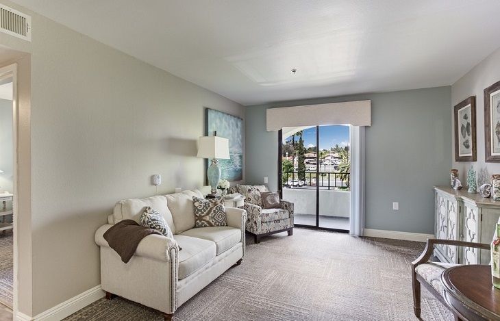 A modern living room featuring a comfortable sofa and armchair with a large window showcasing an outdoor view.