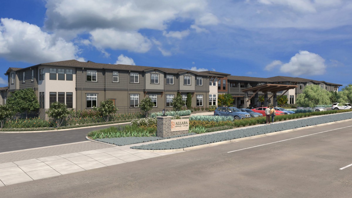 A modern residential building, likely an assisted living facility, with a well-maintained landscape and parking area.