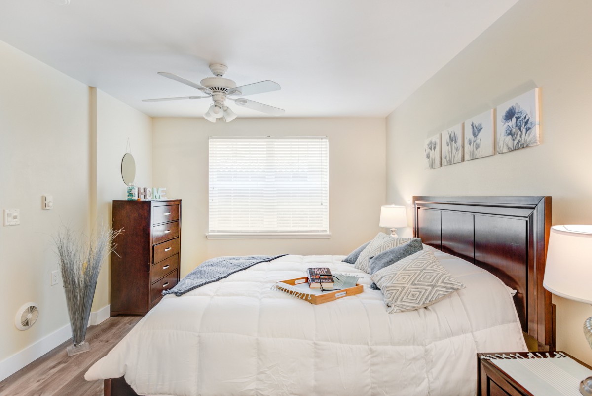 A cozy bedroom with neutral tones featuring a neatly made bed and elegant decor.