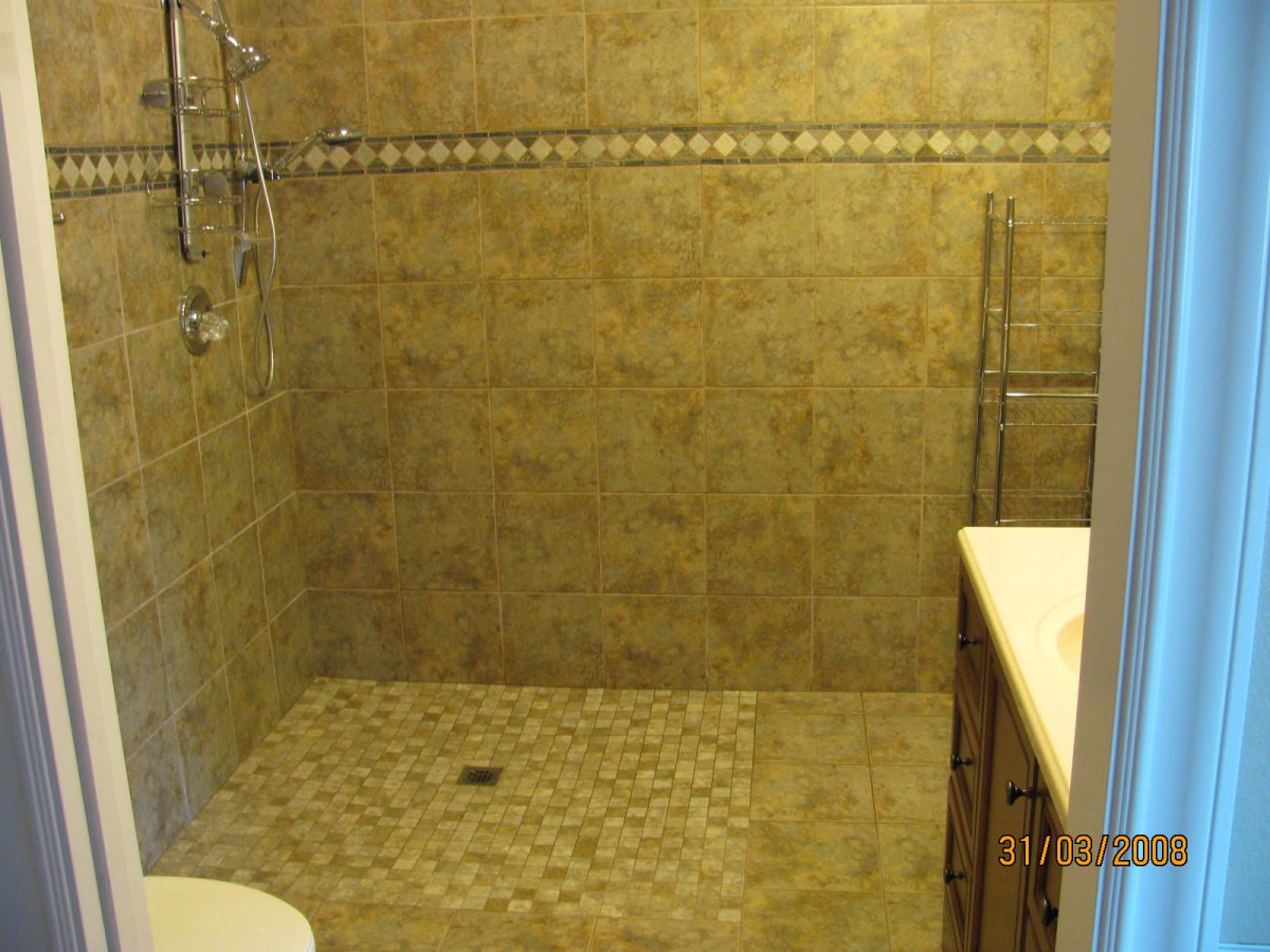 A modern bathroom with tiled walls and a walk-in shower.