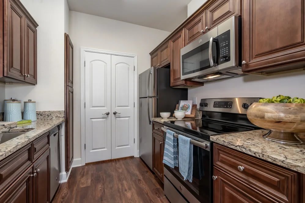A modern kitchen with stainless steel appliances and wooden cabinets.