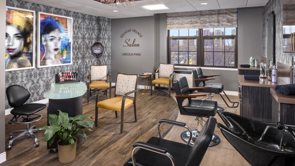 A modern hair salon with a stylish interior, featuring comfortable chairs, large windows, and decorative elements.