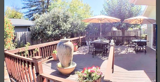 A serene outdoor deck featuring a decorative fountain and dining area, perfect for enjoying sunny days.