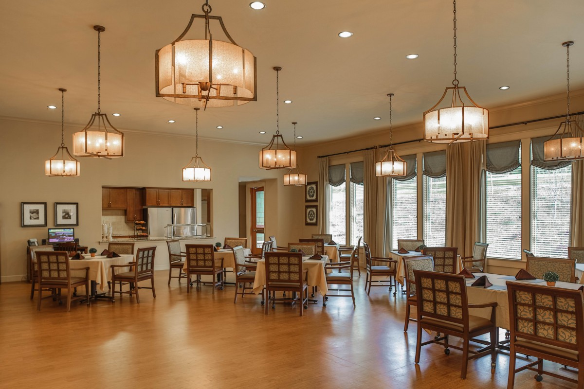 A spacious dining area with elegant lighting and large windows.
