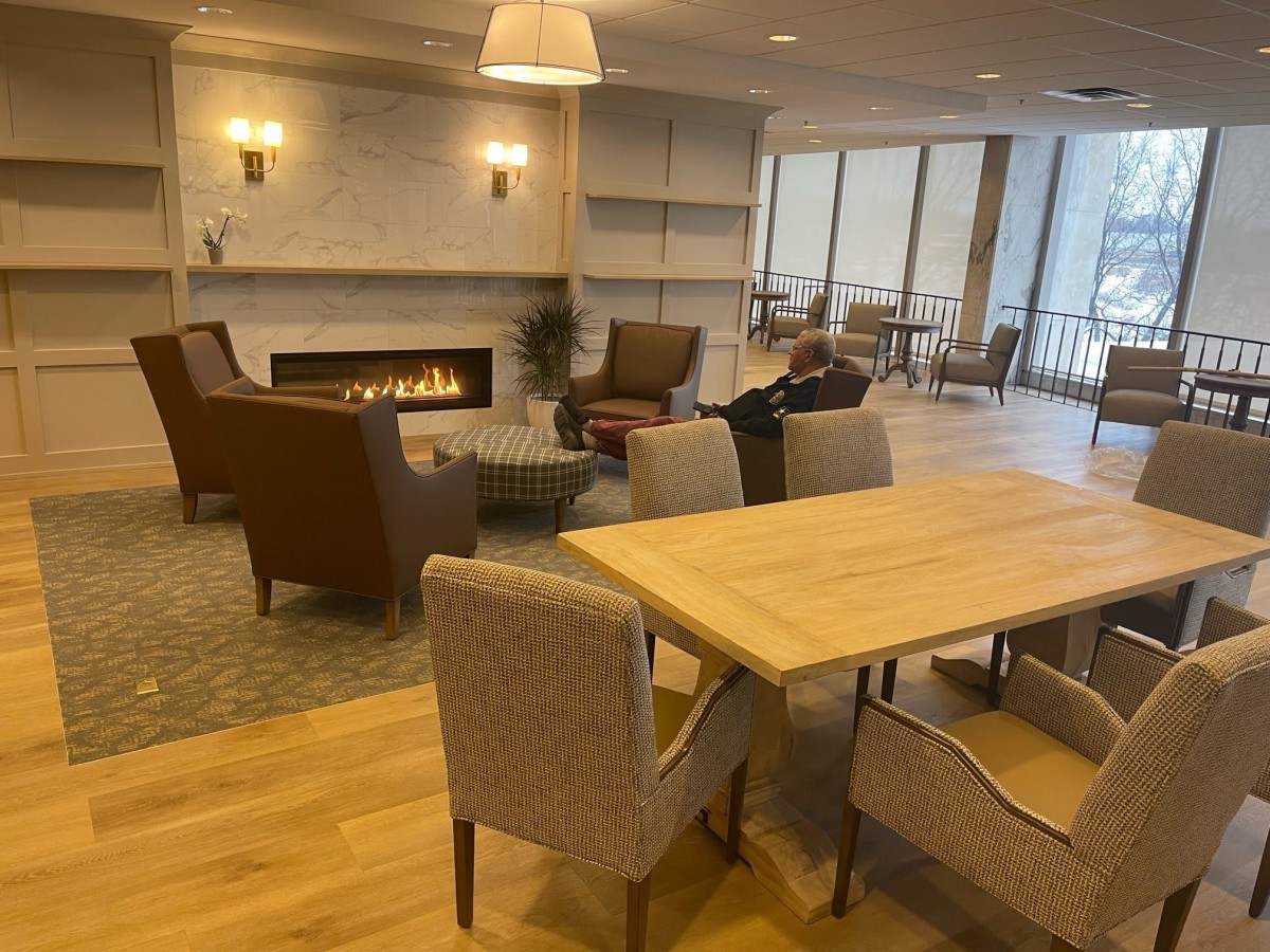 A cozy living room with modern furnishings, featuring a fireplace and comfortable seating.