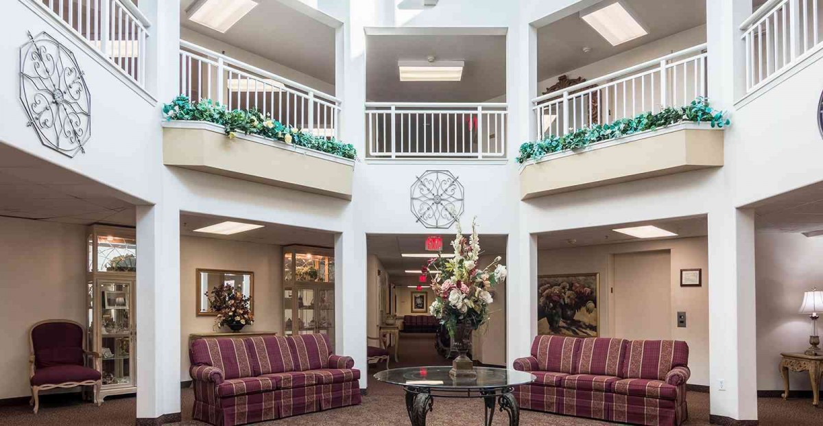 A well-lit lobby area featuring elegant sofas and decorative plants.