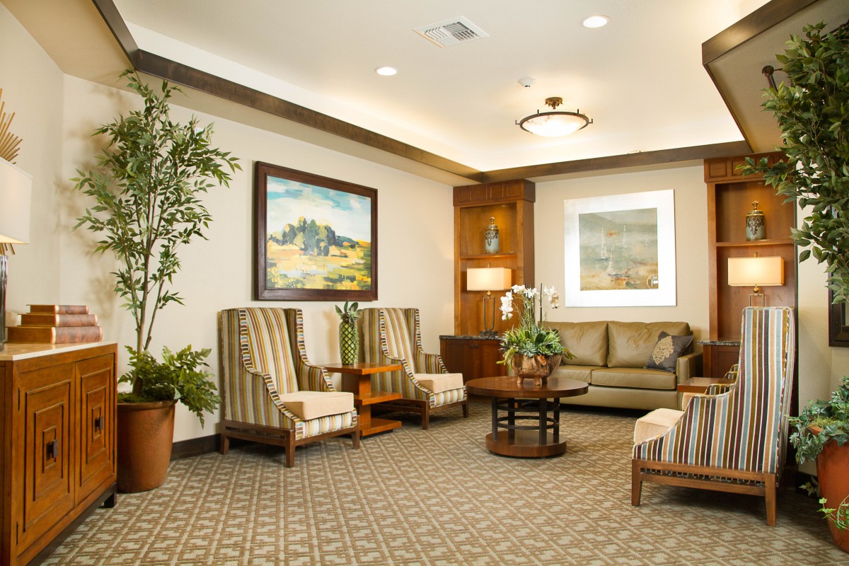 A cozy lobby area with comfortable seating, artwork, and decorative plants.
