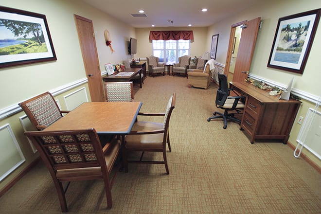 A spacious office interior with desks, chairs, and a table.