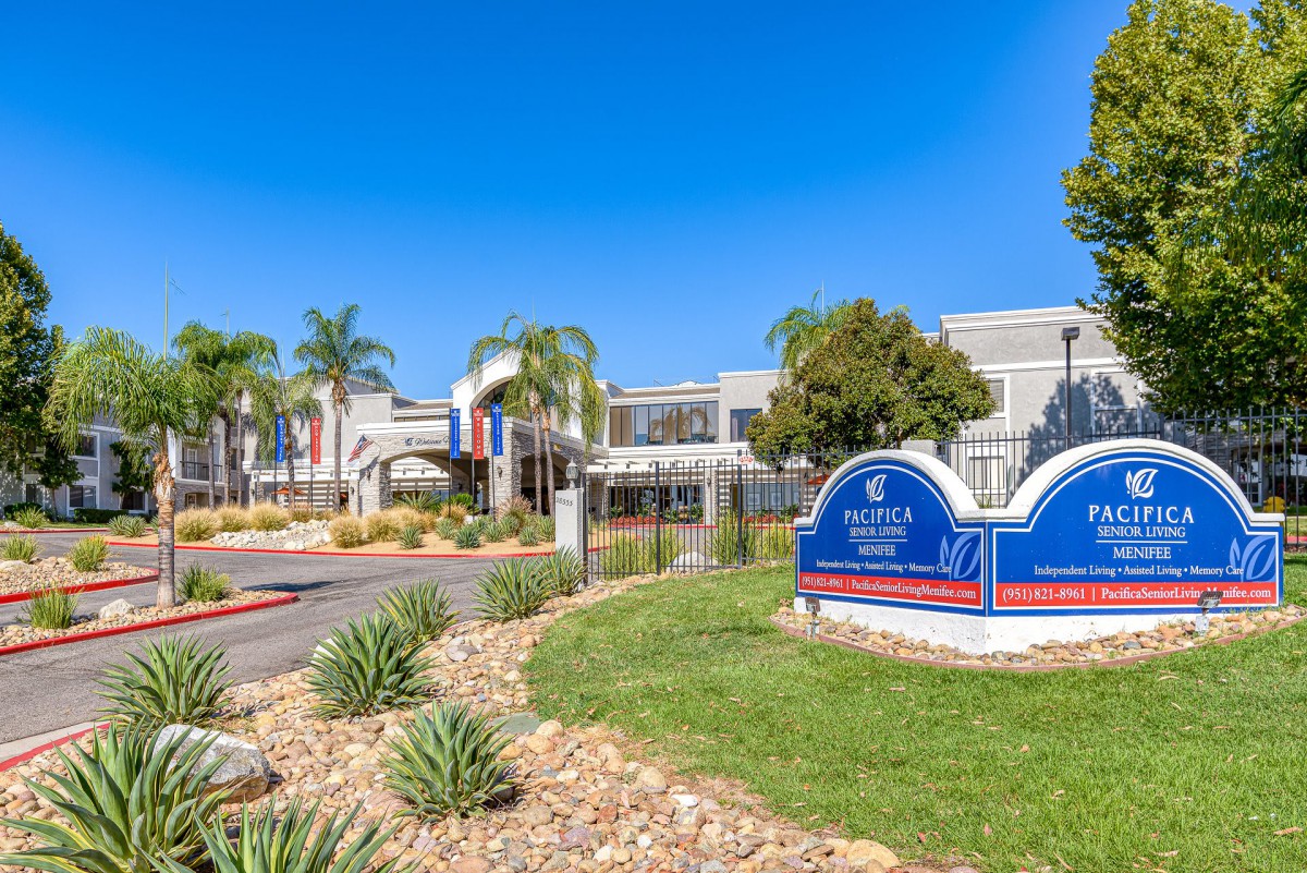 A healthcare facility with landscaped surroundings and clear blue skies.