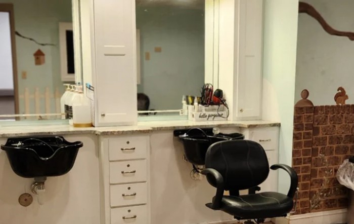 An interior view of a barbershop with chairs and mirrors.