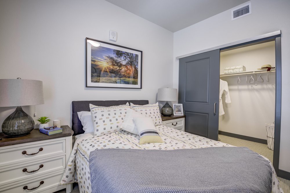 A cozy bedroom with a neatly made bed, closet, and stylish decor.