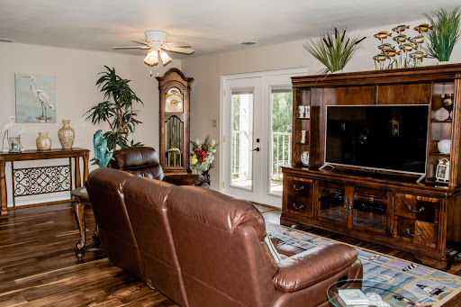 A cozy living room featuring leather seating, a wooden entertainment center, and decorative elements.