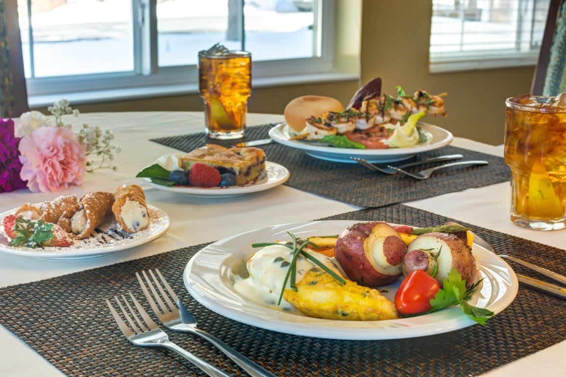 A beautifully set table with a variety of plated dishes and a drink, ready for dining.