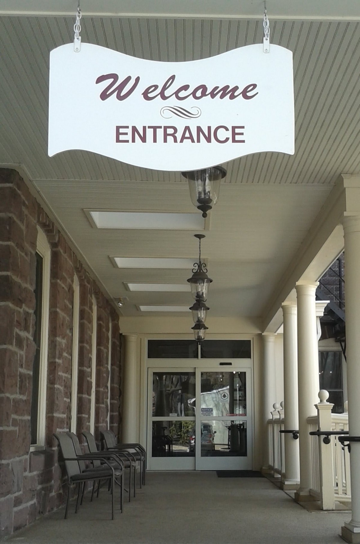 Entrance to a building with a welcome sign above the porch.