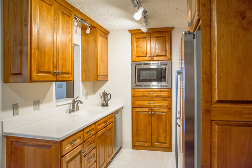 A modern kitchen featuring warm wooden cabinets and sleek appliances.