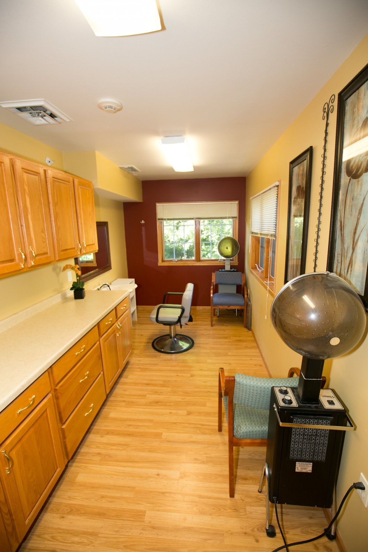 Interior view of a hair salon with wooden cabinets and styling equipment.
