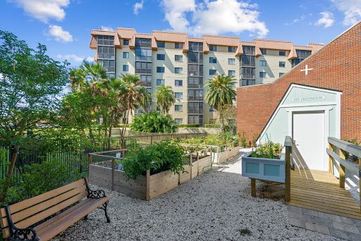 A beautiful view of a modern apartment building surrounded by lush landscaping and garden areas.