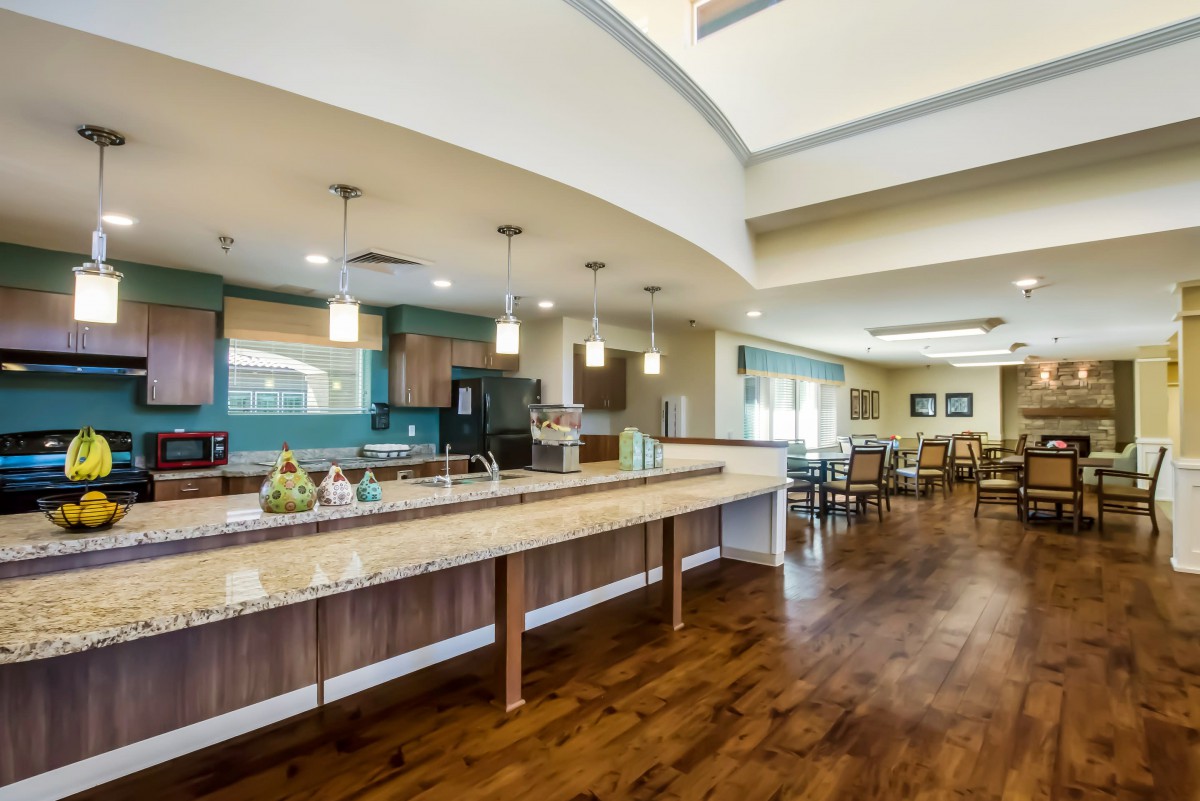 A spacious and modern kitchen with a dining area, featuring wooden floors and contemporary lighting.