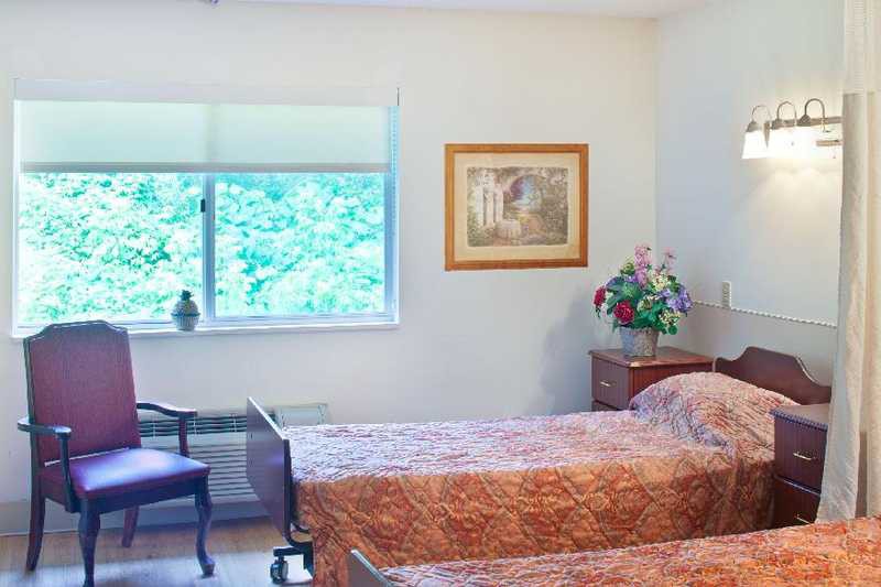 A cozy bedroom with twin beds and a decorative flower arrangement.