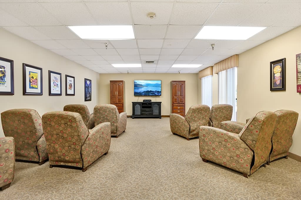 A cozy seating area with comfortable chairs arranged around a television.