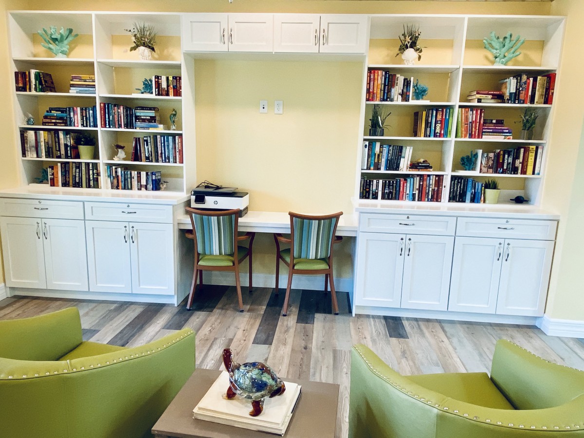 A cozy study area with built-in bookshelves and two workstations.