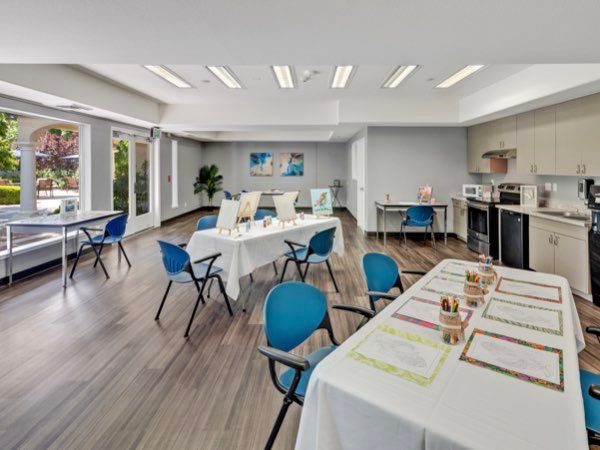 A modern meeting room setup with tables and blue chairs, ready for a conference.