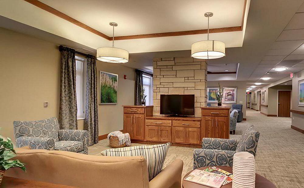A cozy living room with modern furniture and a television, featuring a warm and inviting seating arrangement under stylish lighting fixtures.