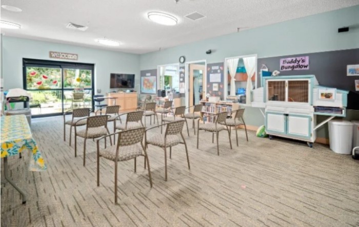 A well-organized classroom with chairs, desks, and educational materials displayed on the walls.