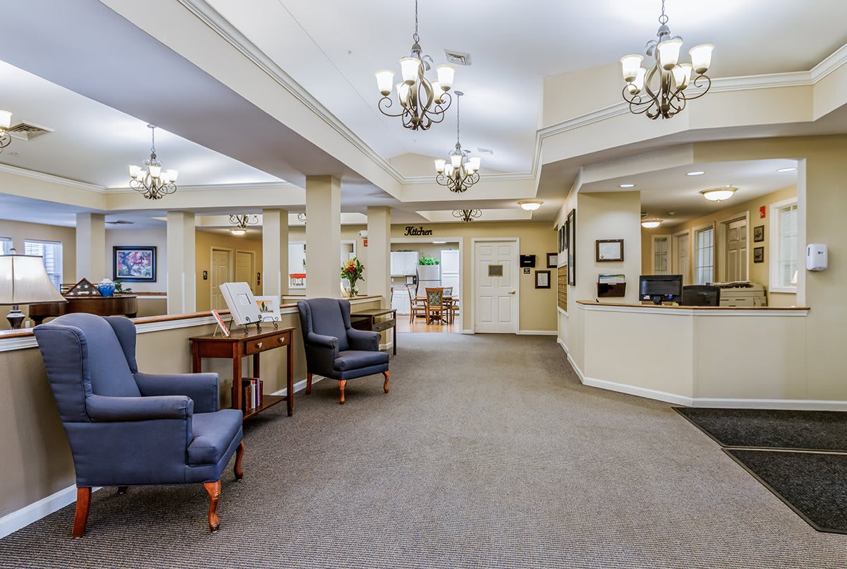 A spacious and well-lit lobby area featuring comfortable seating and a reception desk.
