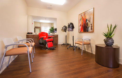 A cozy waiting area in a hair salon featuring comfortable seating and vibrant artwork.