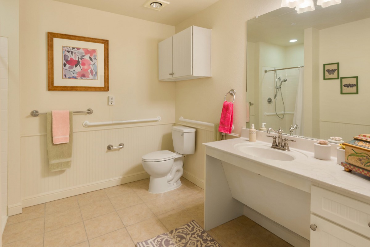 A modern bathroom with a toilet, sink, and shower area.