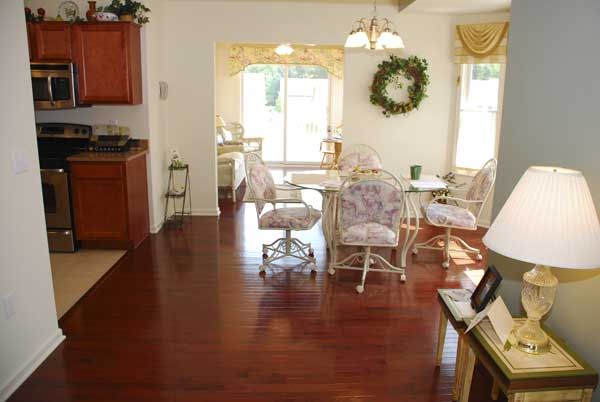 A cozy dining area with floral seating and hardwood floors.