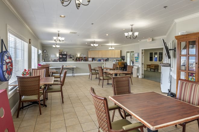 A well-lit dining area with tables and chairs arranged neatly.
