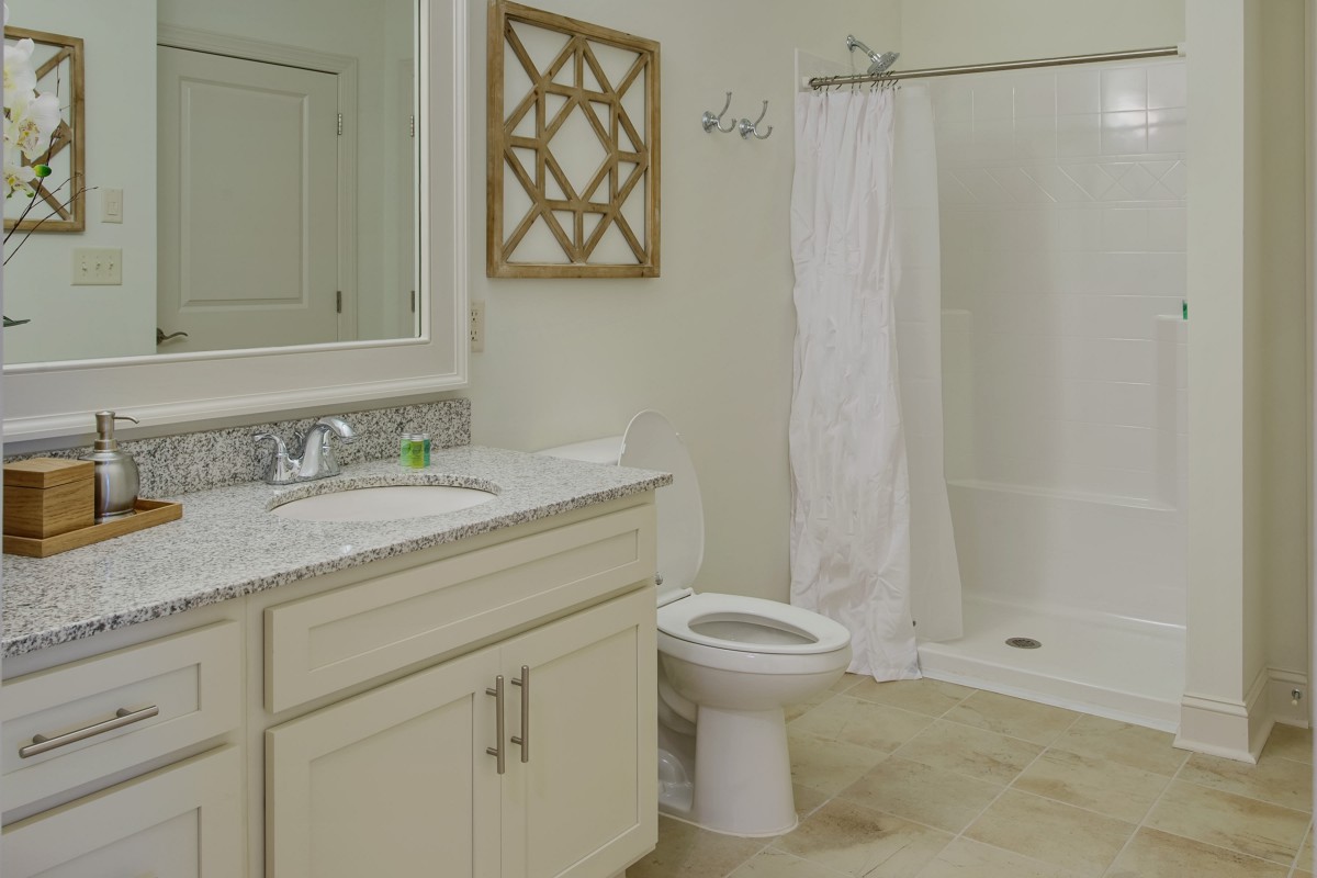A clean and modern bathroom with a shower, sink, and toilet.