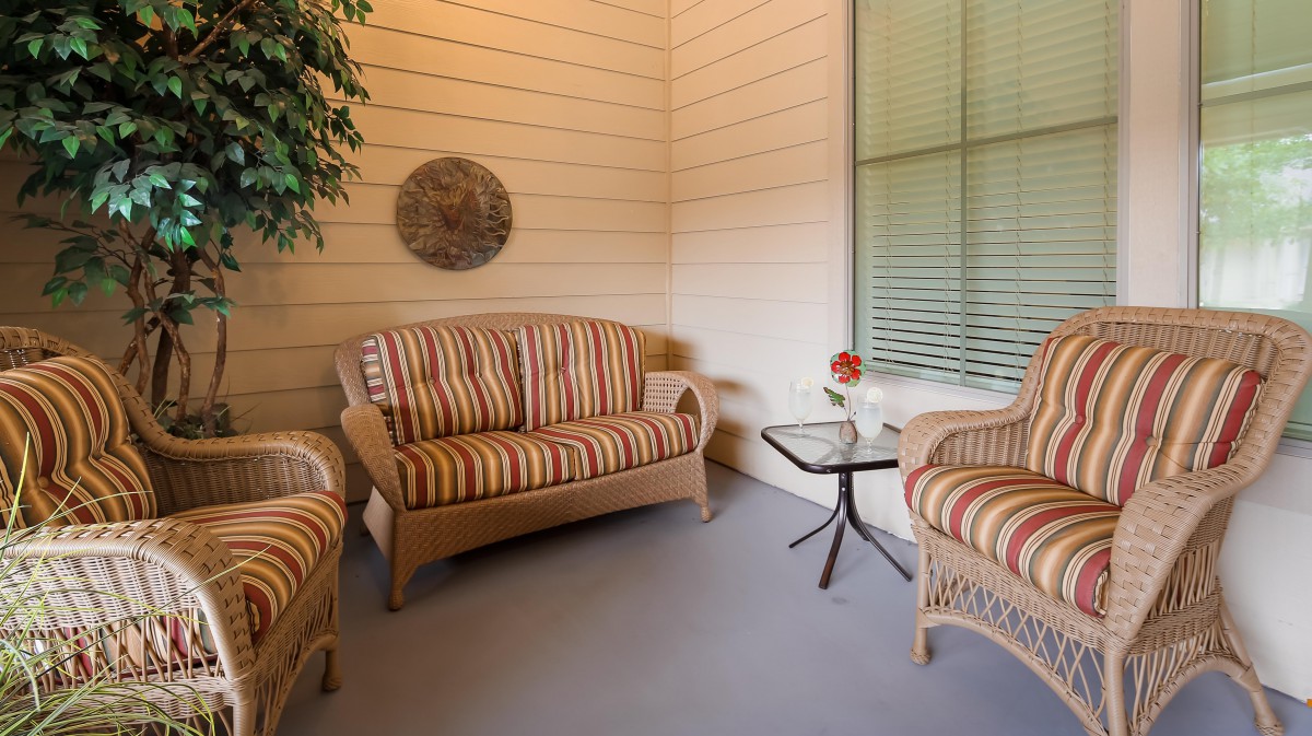Cozy patio area with striped furniture and a small glass table.