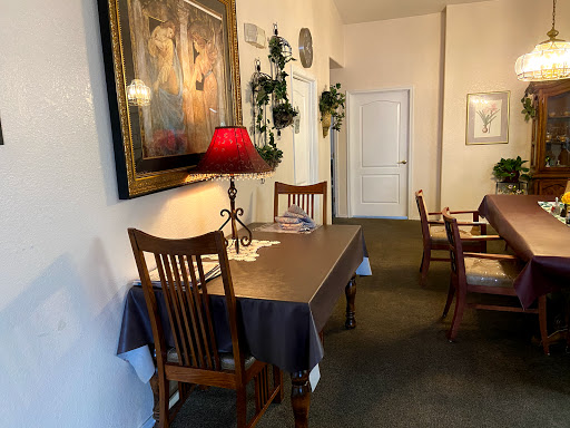 A cozy dining area featuring a wooden table with a lamp and tasteful wall decor.