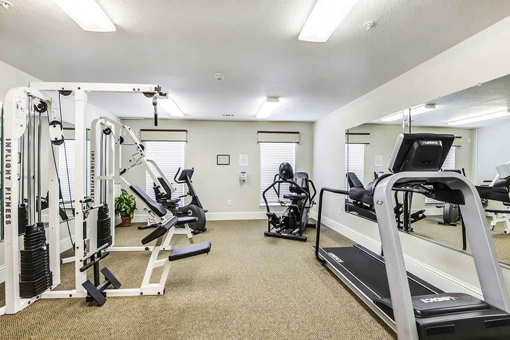 A fitness room with various exercise machines and equipment.