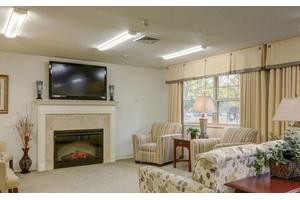 Cozy living room with a television above the fireplace, surrounded by comfortable seating.