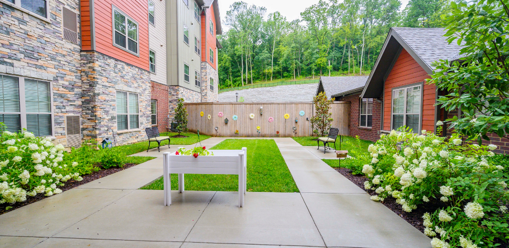 A well-maintained courtyard with a pathway and greenery, surrounded by buildings.