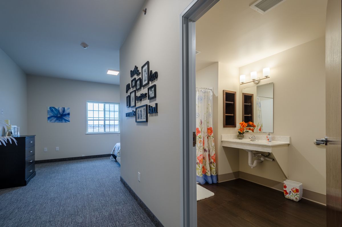 A modern home interior featuring a hallway leading to a decorated bathroom.