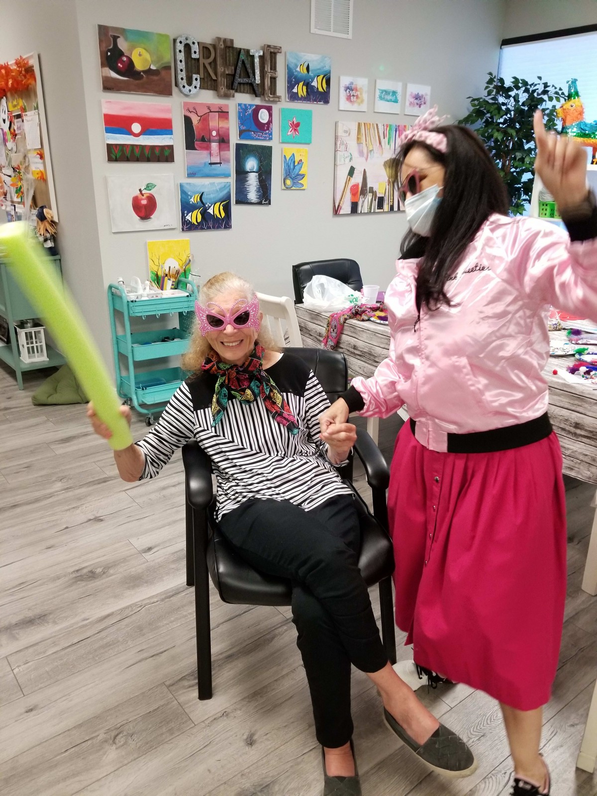 Two people in costume having fun indoors with props.