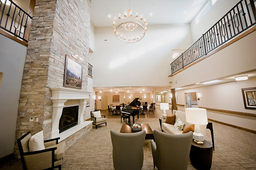 A spacious and elegantly designed living room with a chandelier, fireplace, and comfortable seating.