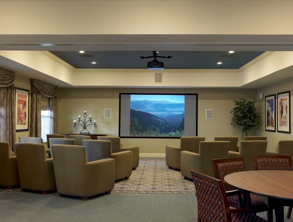 A cozy theater room with a large screen and comfortable seating.