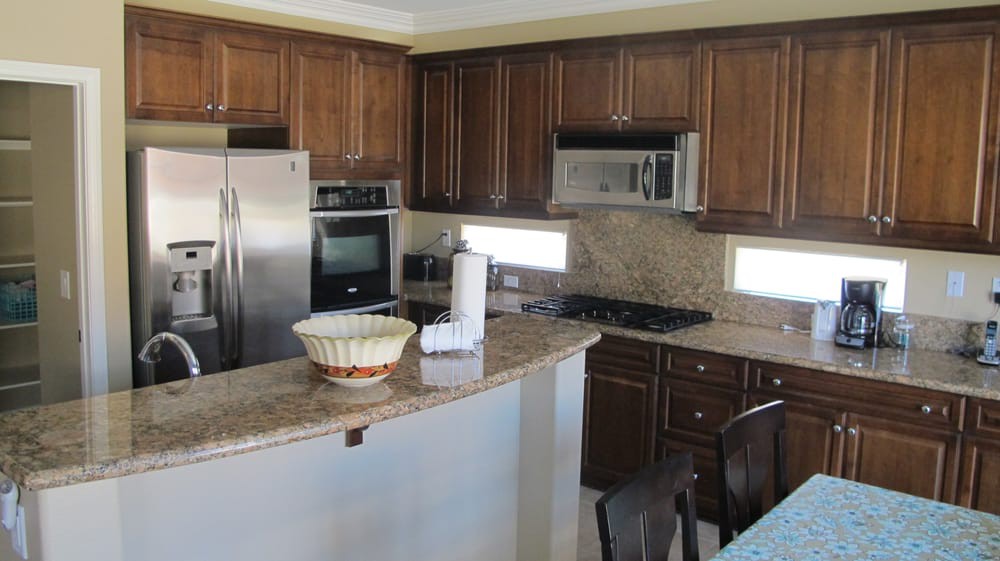 A modern kitchen with wood cabinets and stainless steel appliances.