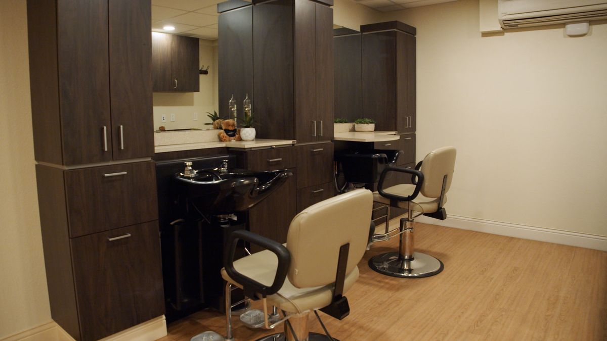 A modern hair salon with styling stations and barber chairs.