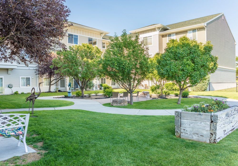A well-maintained apartment complex with lush green lawns and trees.